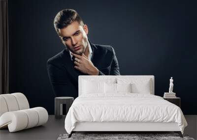 Portrait of handsome man in a studio on a dark background Wall mural