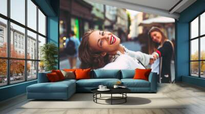 Two young happy women in the city Wall mural