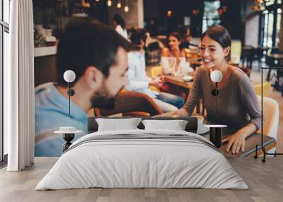 Young happy couple at a date in a coffee shop Wall mural