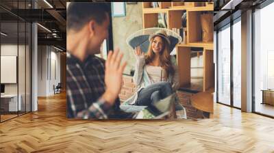 Young man and woman say hi each other in cafe flirting situation Wall mural