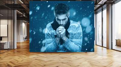 Young man is freezing in the snow Wall mural