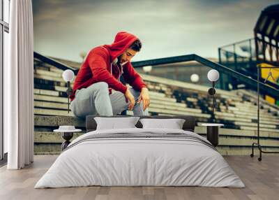 Young man resting on the stairs after running Wall mural