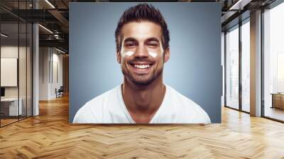 Young man with moisturizer on the face Wall mural