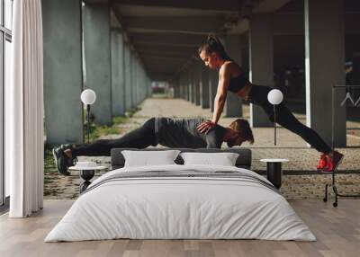 Young sports couple exercising in the urban environment Wall mural