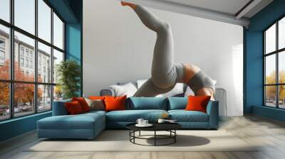 Young woman doing yoga at home Wall mural