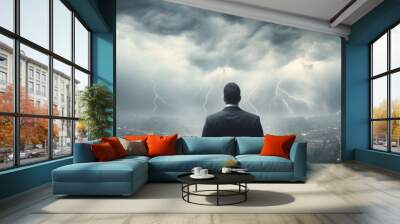 A leader standing confidently with crossed arms in front of a visual of tumultuous weather, representing steadiness in navigating the storm Wall mural