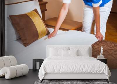 Maid making bed in hotel room Wall mural