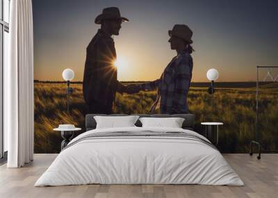 Man and woman are working together in partnership. They are cultivating barley. Wall mural