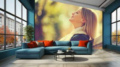 Young happy woman enjoying fresh air in autumn, intentionally toned. Wall mural