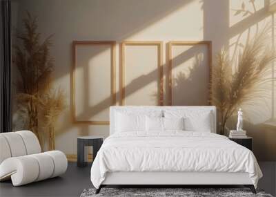 A white room with three empty frames on the wall and two potted plants Wall mural