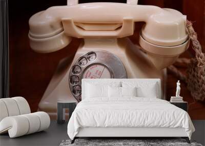 Close-up of antique white rotary telephone on a woodern desk. Wall mural