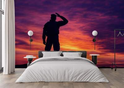 Silhouette of a soldier saluting at sunset, respect and honor associated with military service Wall mural