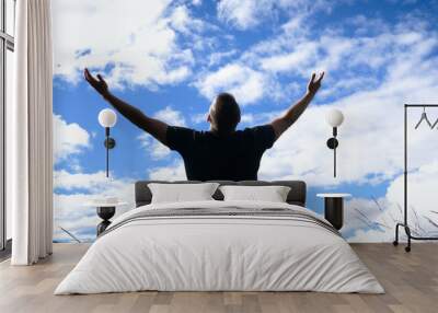 Reach out for the sky - A man opens out his arms facing a vibrant misty sky standing on top of a hill. Wall mural