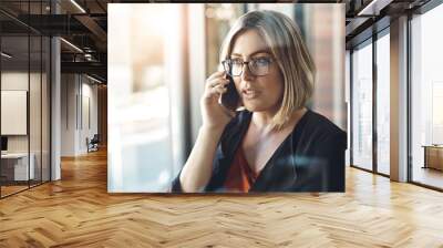 Phone call, talking and woman in office, serious and communication for investment and proposal for trader. Business, window and conversation with contact, working and entrepreneur with mobile Wall mural