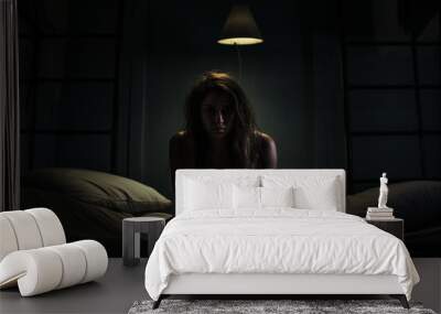 Sad desperate young teenager female girl suffering from online bullying harassment feeling lonely hopeless sitting bed at night CYberbullying dangers internet depression sadness melancholy dark tones Wall mural