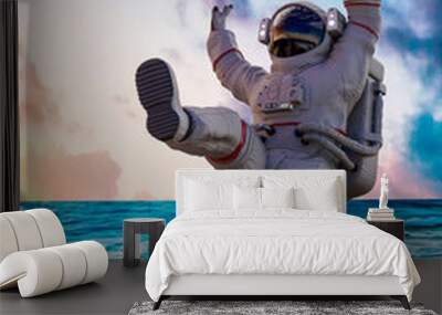 astronaut falling on holiday with a sunset beach as background Wall mural