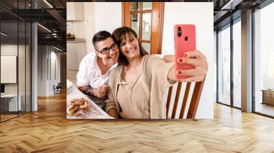 Lesbian couple taking a selfie during Christmas lunch Wall mural