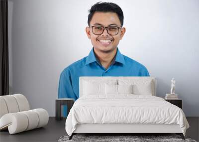 portrait smiling or happy asian young businessman with glasses standing and looking camera wearing blue shirt isolated on white background Wall mural