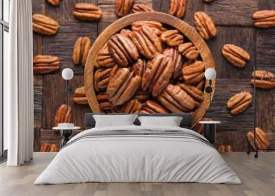 pecan nuts peeled in wooden bowl, top view. Wall mural