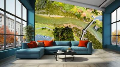 Aerial view of the countryside with a small bridge across a river and recreation area with car parking. Auckland, New Zealand. Wall mural