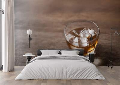 Close-up of a glass of scotch with ice cubes on a wooden table Wall mural