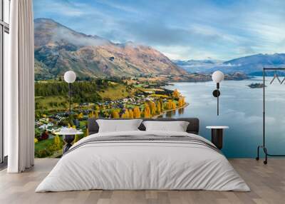 Small town surrounded by yellow autumn trees on a shore of pristine lake with mountains on the background. Wanaka, Otago, South Island, New Zealand Wall mural