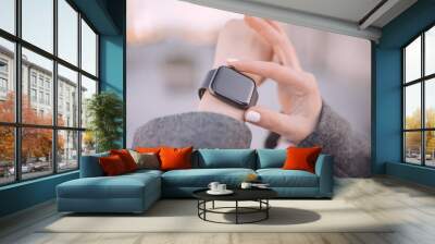 Close-up of woman hands setting smart watch. Wall mural