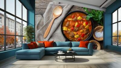 Goulash, beef stew or bogrash soup with meat, vegetables and spices in cast iron pan on wooden table. Hungarian cuisine. Rustic style. Top view. Wall mural