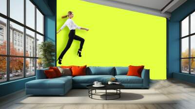 Happy young woman in formal wear jumping. Wall mural