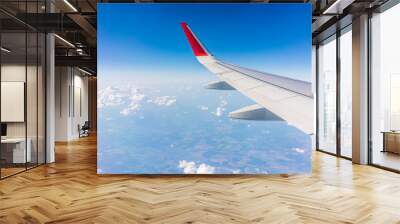 View from the airplane window at a beautiful cloudy sky and the airplane wing Wall mural