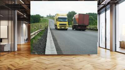 Two trucks on the new road surface. No markings on the road surface. Wall mural