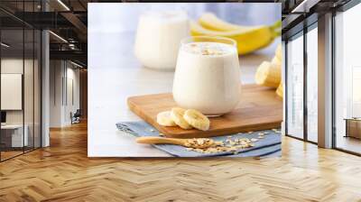 Vegan banana and oatmeal smoothie in glass jar on the light background. Healthy food. Wall mural