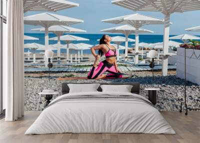 Beautiful sportswoman yoga gymnastics fitness on the beach by the sea Wall mural