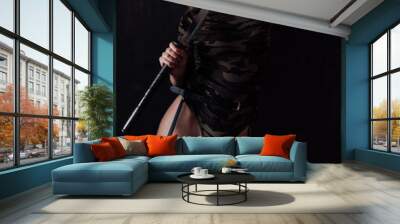 Beautiful woman with a katana in military clothes on a black background Wall mural