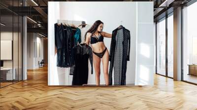 Closet woman can't decide what to wear, confused by outfits needing to organize closet with too many clothing. Wall mural