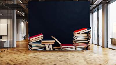 lots of stacks of educational books to teach at the college library on a black background Wall mural