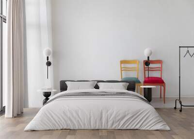 Two old vintage chairs in the interior of a white room near the wall Wall mural