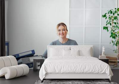 woman in business suit at work in office at a table with books and documents Wall mural