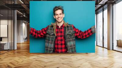 A man in a plaid jacket is smiling and holding his arms out to the side Wall mural