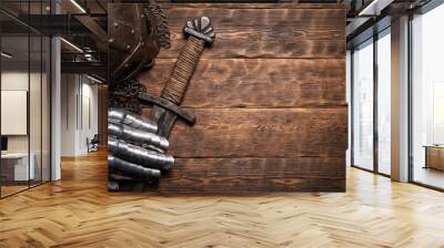 Ancient knight sword and armor on the wooden table flat lay background with copy space. Wall mural