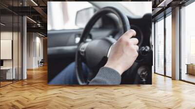 Driver is sitting by a steering wheel close up. Wall mural