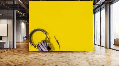 Flat lay closeup music black studio headphones on yellow background with shadow Wall mural