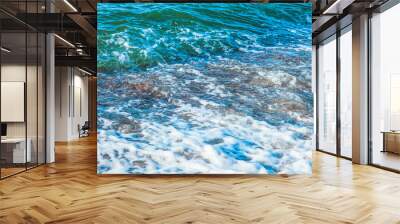 pure azure clear water with white foam on the sea on a sunny afternoon, blurry background Wall mural