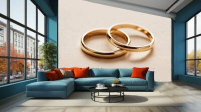 Two gold wedding bands on a beige surface Wall mural