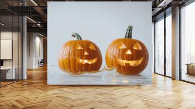 Two illuminated jack-o'-lanterns float in water Wall mural