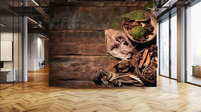 Witchcraft flat lay concept background with copy space. Herbs and dry plants on the brown wooden table background. Wall mural