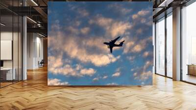 Silhouette of the plane in the clouds at sunset Wall mural