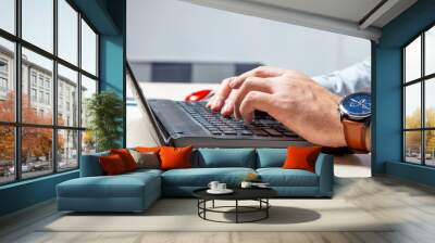 A man types on the keyboard. Hands and fingers on buttons close up Wall mural