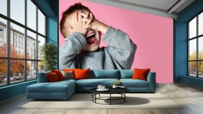 Baby boy kid covering close his eyes with hands and palms screaming laughing  over pink Wall mural