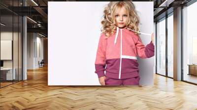 Beautiful curly hair blonde baby girl kid in modern fashion hoodie posing with text space on white  Wall mural